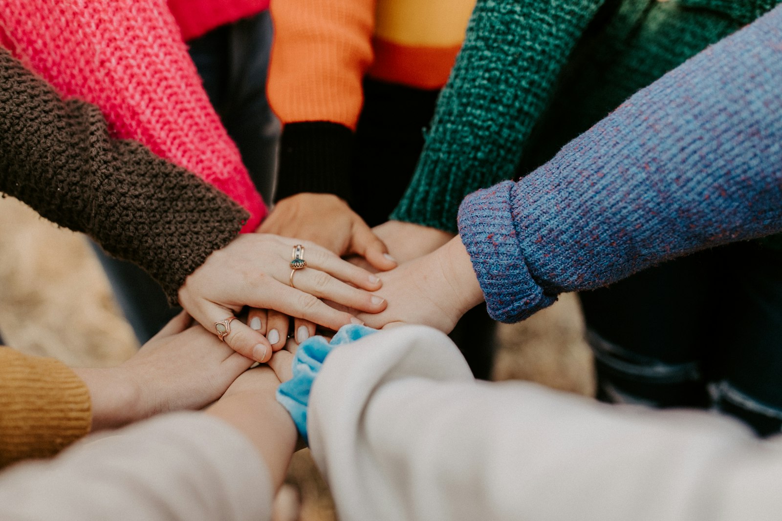 Diverse group of community members joining hands